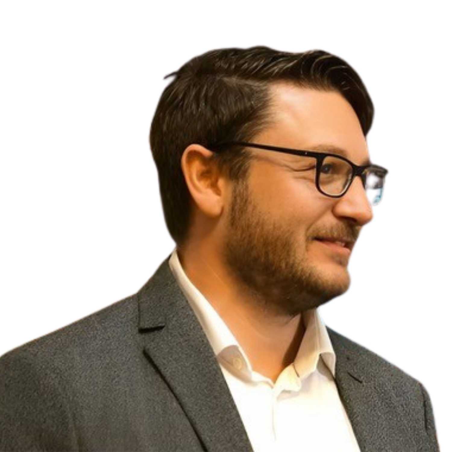 Porträt eines Mannes mit Brille, dunklem Haar und Bartansatz in grauem Sakko und weißem Hemd vor hellem Hintergrund. Er blickt seitlich aus dem Bild.