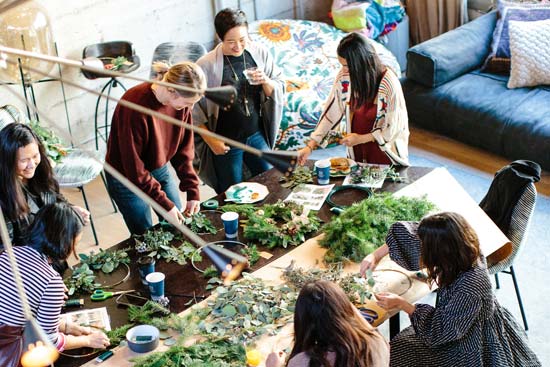 Eine Gruppe von Frauen bastelt gemeinsam Girlanden
