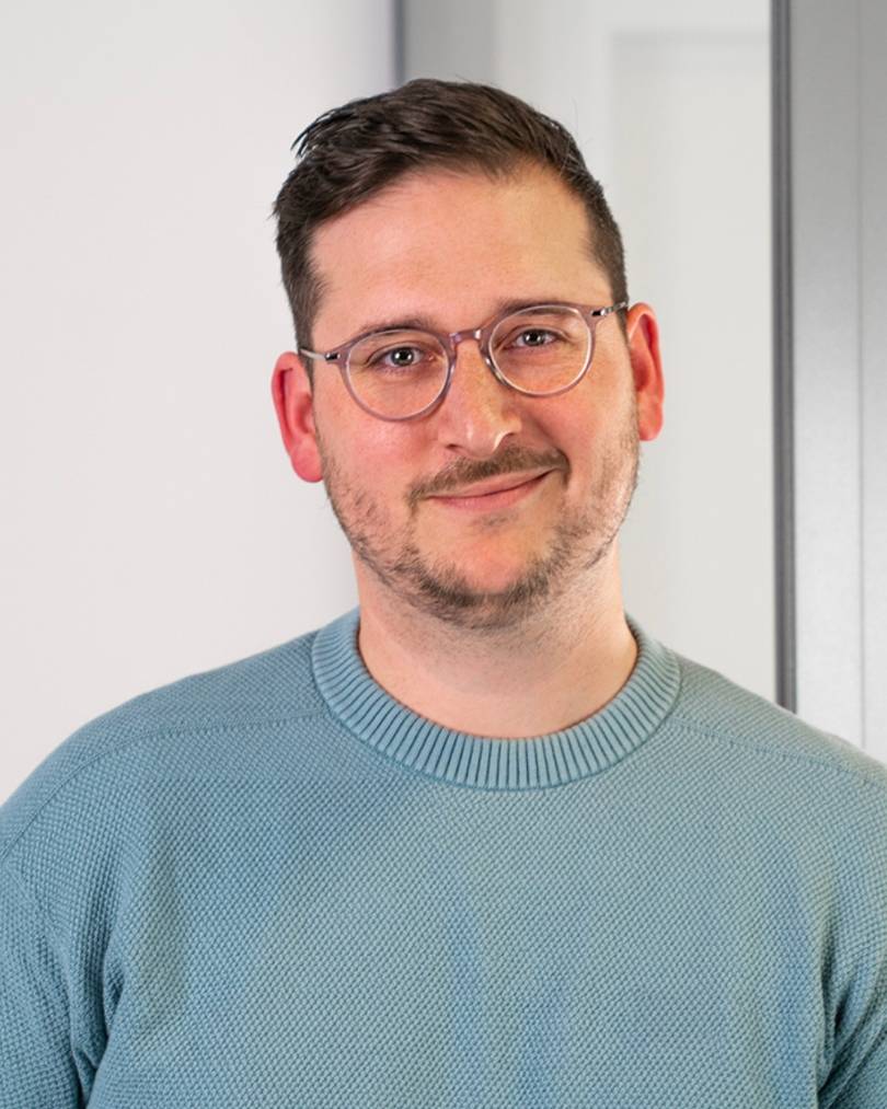 Bild von einem Mann mit Brille vor einem hellen Hintergrund