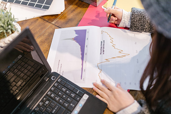 Bild einer Frau, die an Diagrammen arbeitet